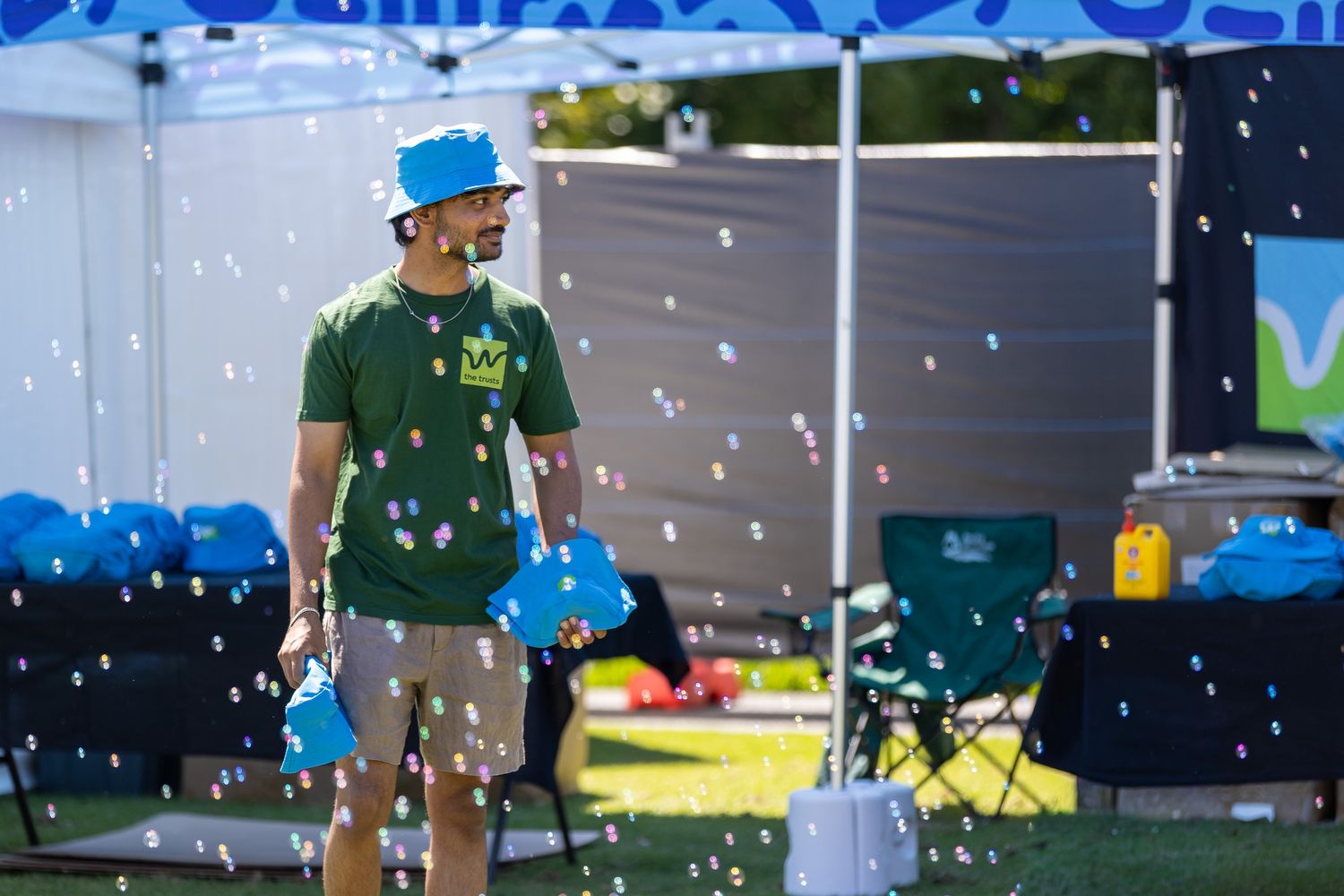 Outdoor event scene with confetti falling and staff in branded uniforms.