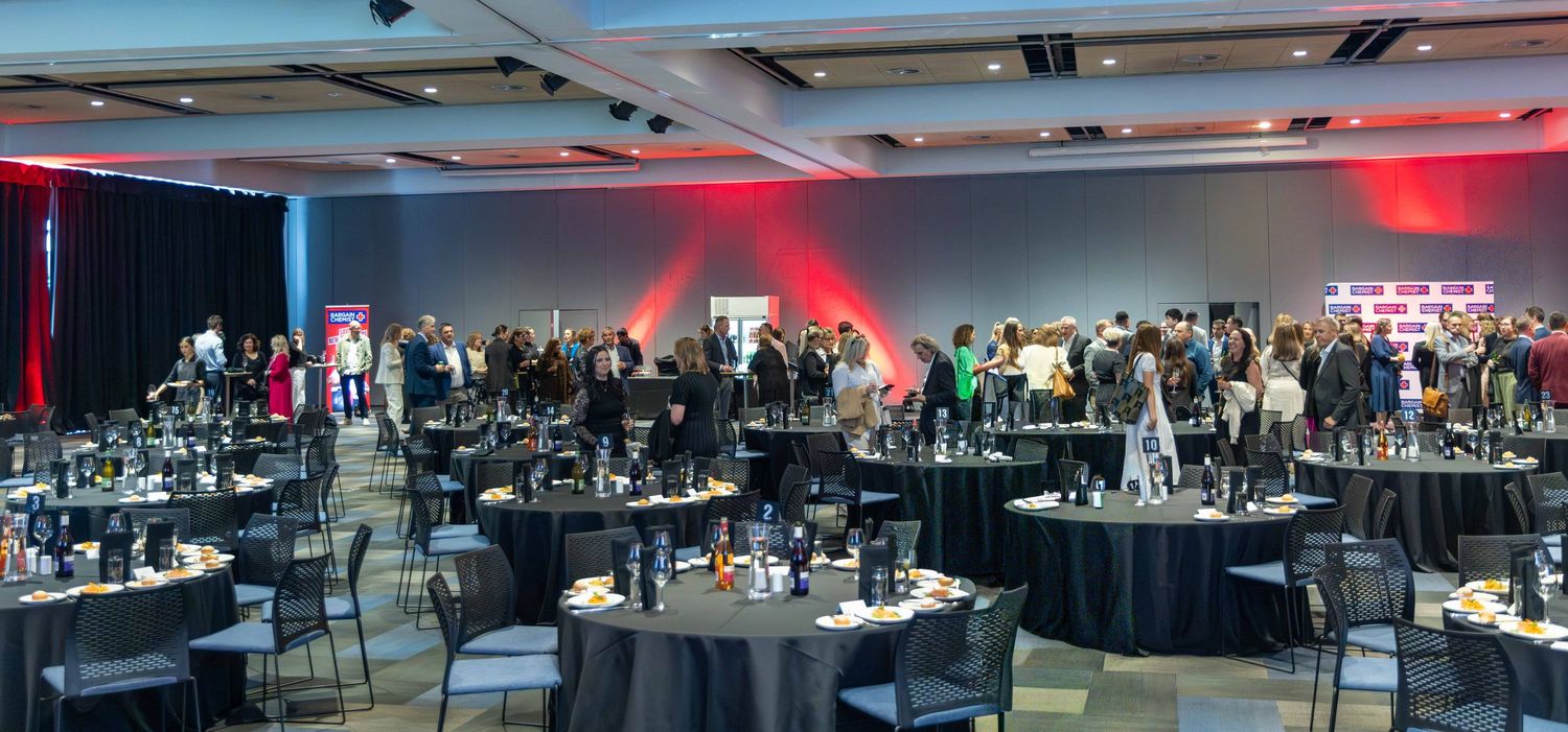 Wide-angle view of a spacious event venue with dramatic lighting and table settings.
