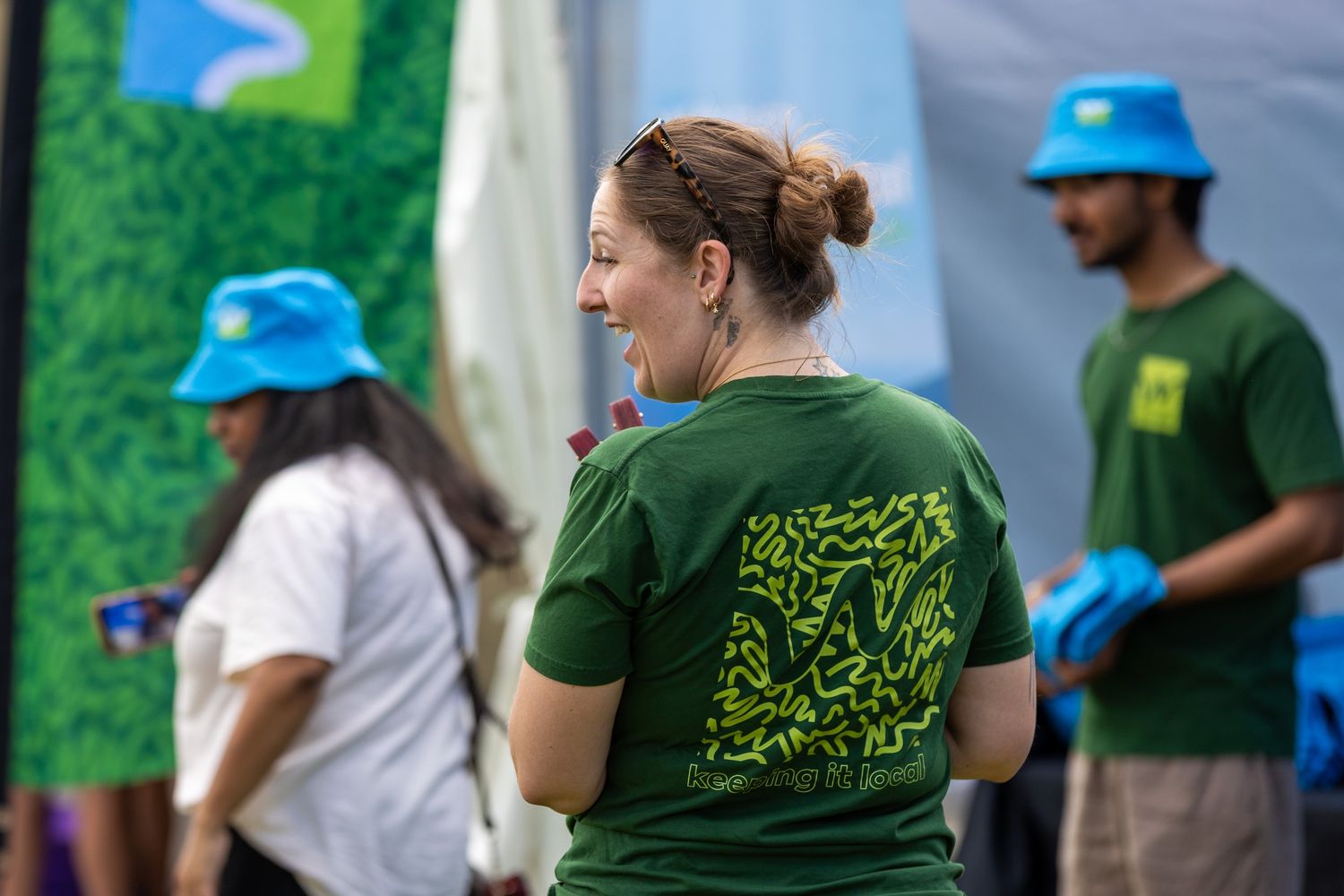 Staff members in branded shirts working at an outdoor festival booth.
