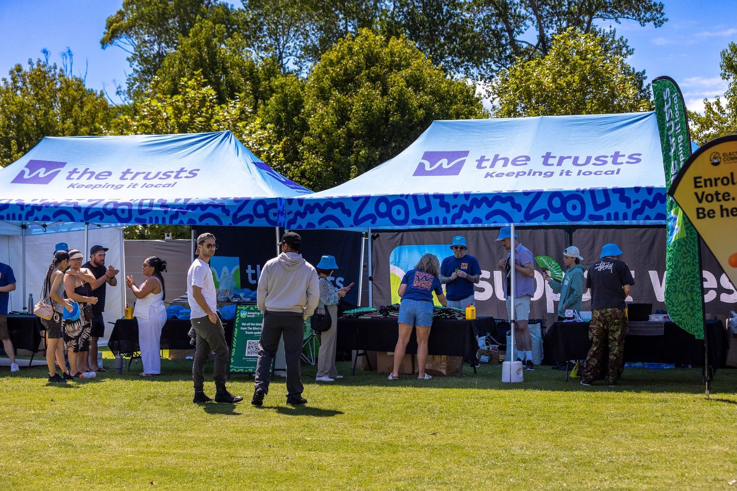 Visitors exploring promotional booths under branded blue and white tents.