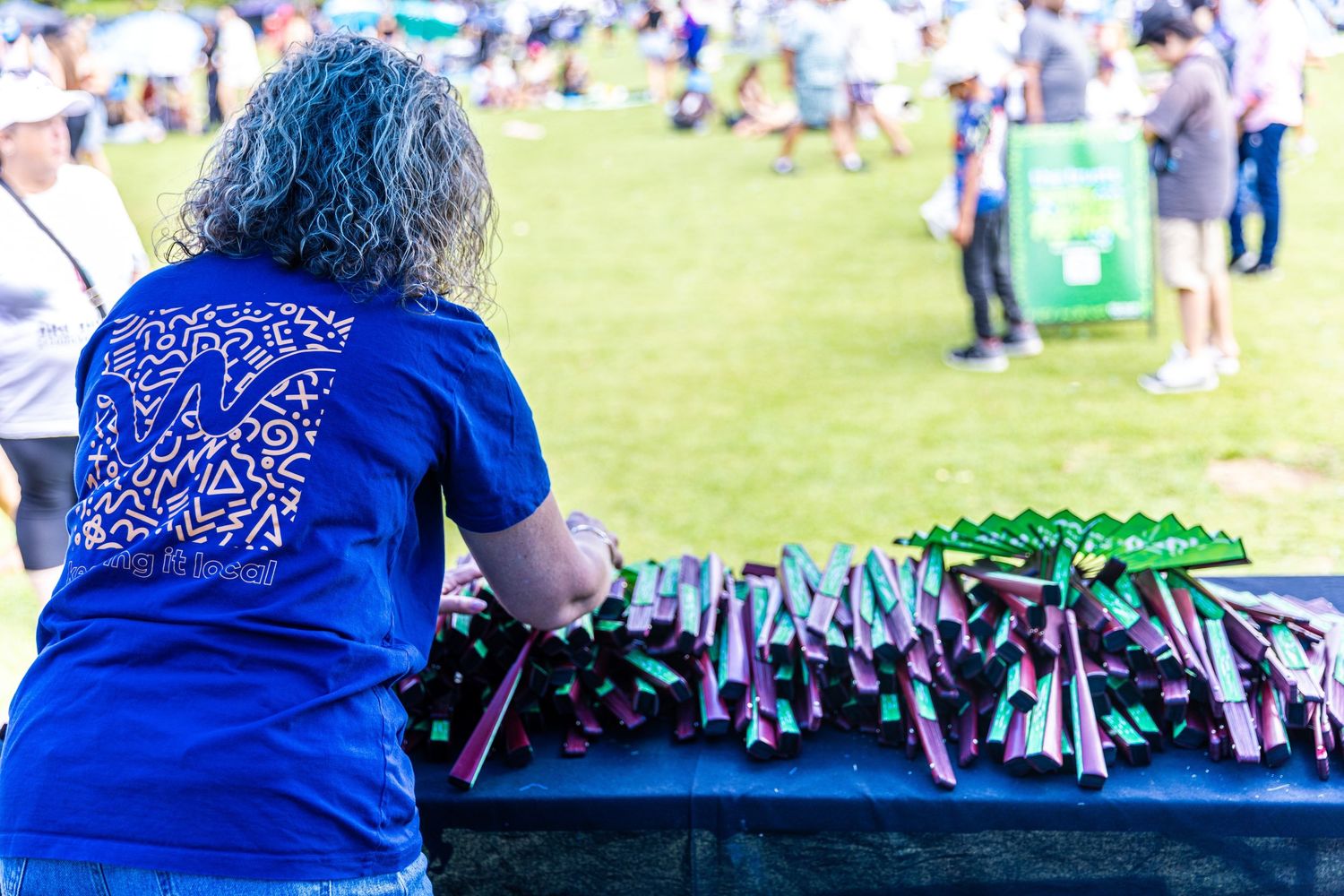 Outdoor event setup with merchandise tables and promotional displays.