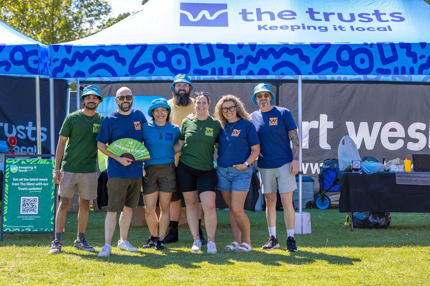 Outdoor event setup with The Trusts branding banner and signage.