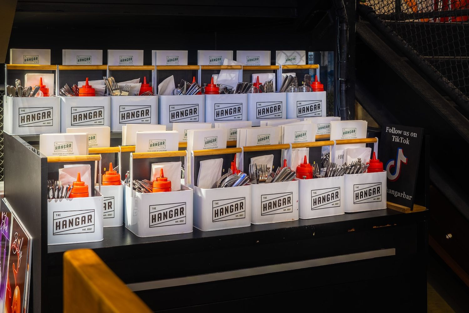 Rows of white cigarette cartons displayed on dark retail shelves with red price tags.