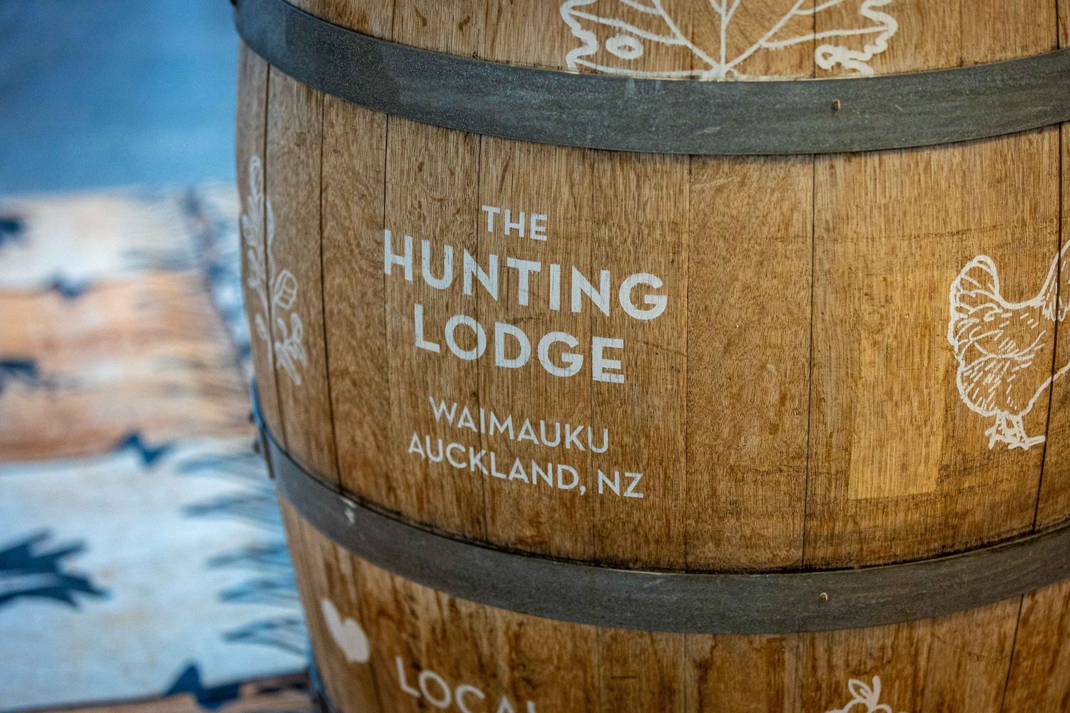 Wooden barrel engraved with The Hunting Lodge Waimauku Auckland NZ logo at a New Zealand winery.