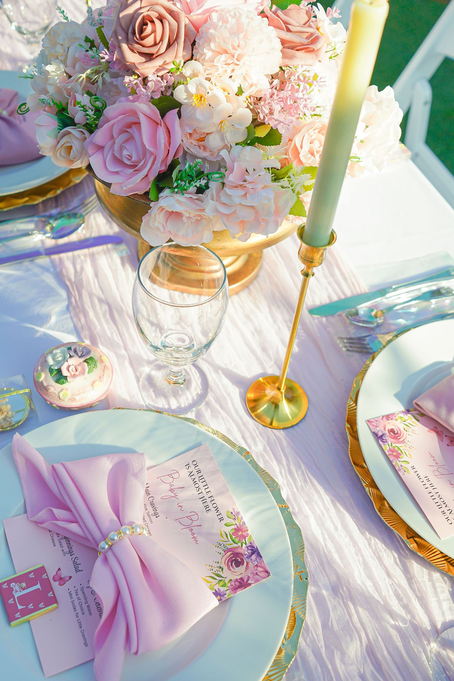 Romantic table setting with pink roses, gold chargers, and lavender accents.