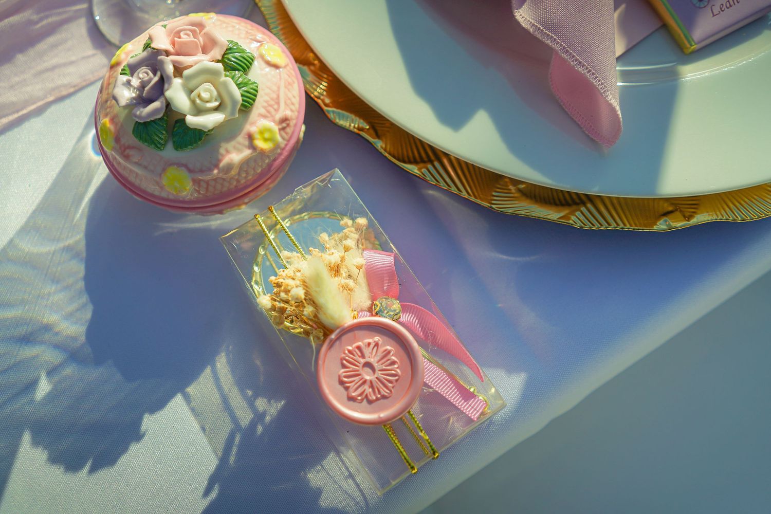 Decorative party favors and treats with pink and gold details in sunlight.