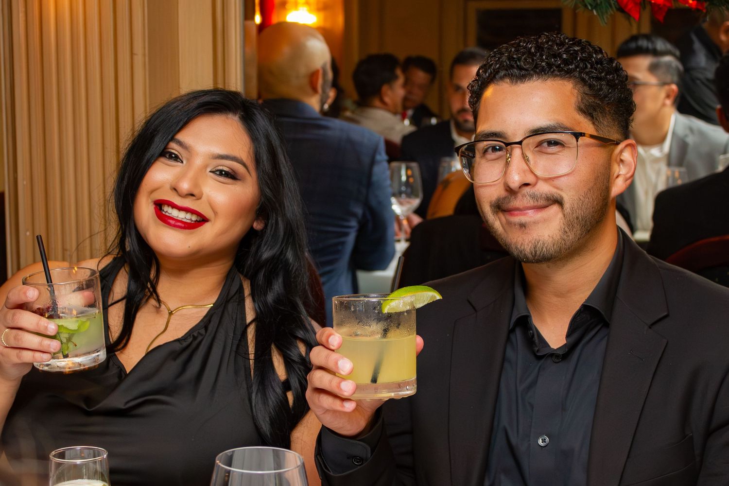 Couple enjoying cocktails with lime garnishes at an upscale evening event.