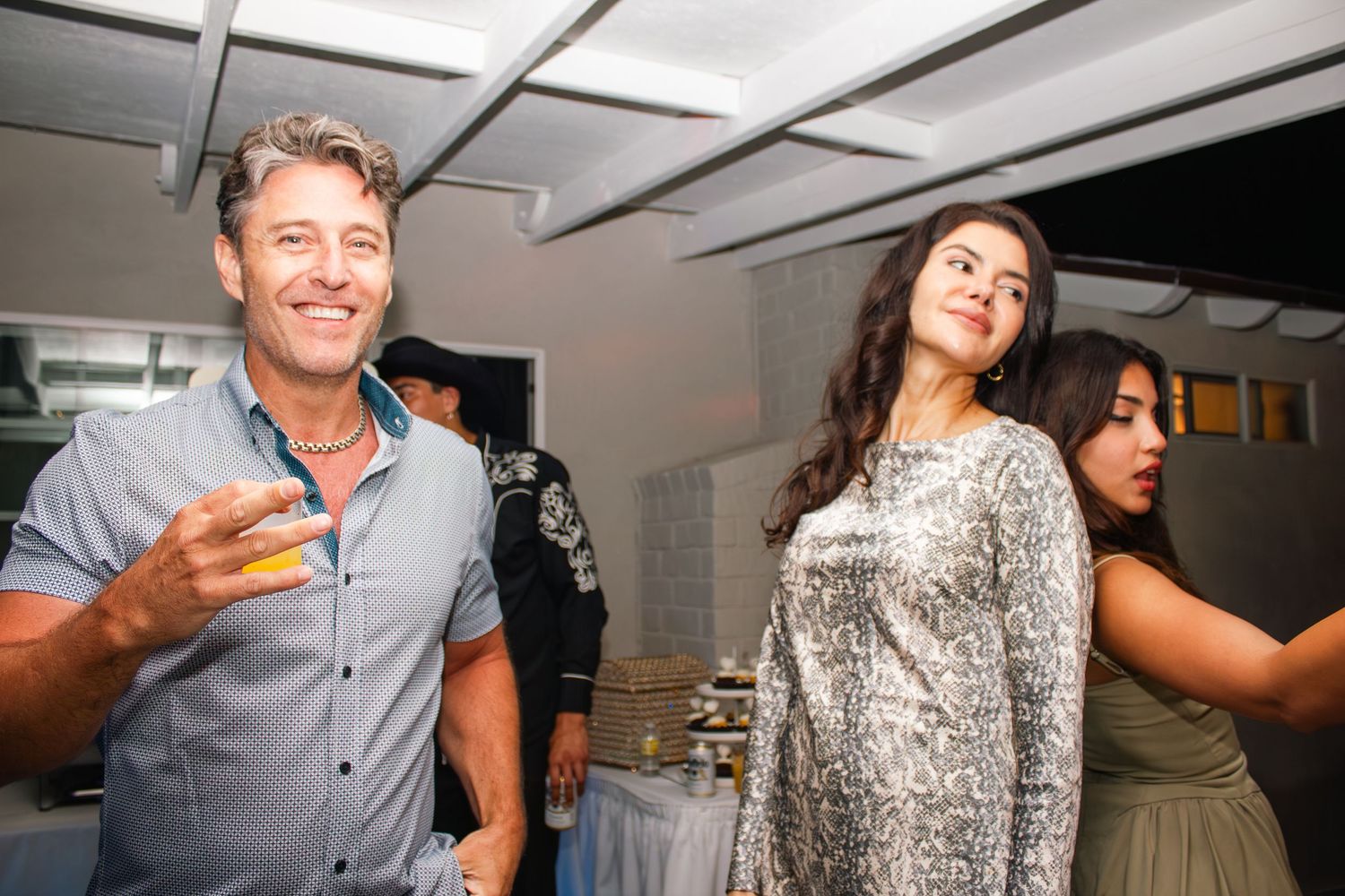 Party guests enjoying themselves during a lively celebration indoors.