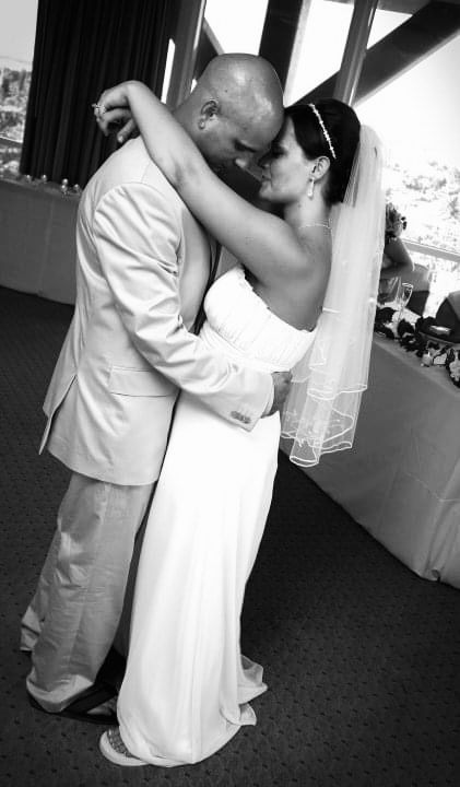 Black and white photo of a bride and groom sharing a tender first dance embrace.