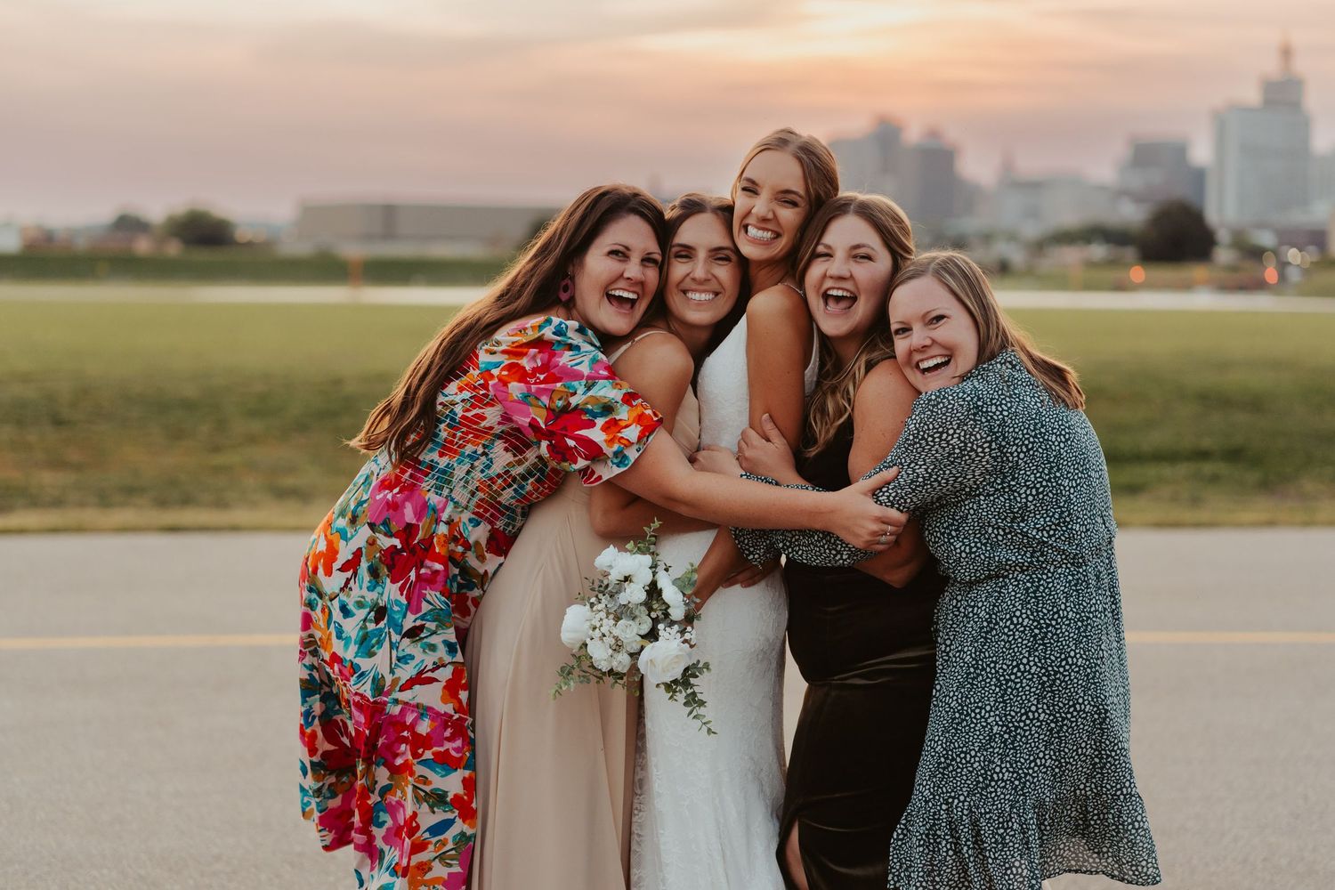 Bride poses with her cousins during a beautiful sunset.