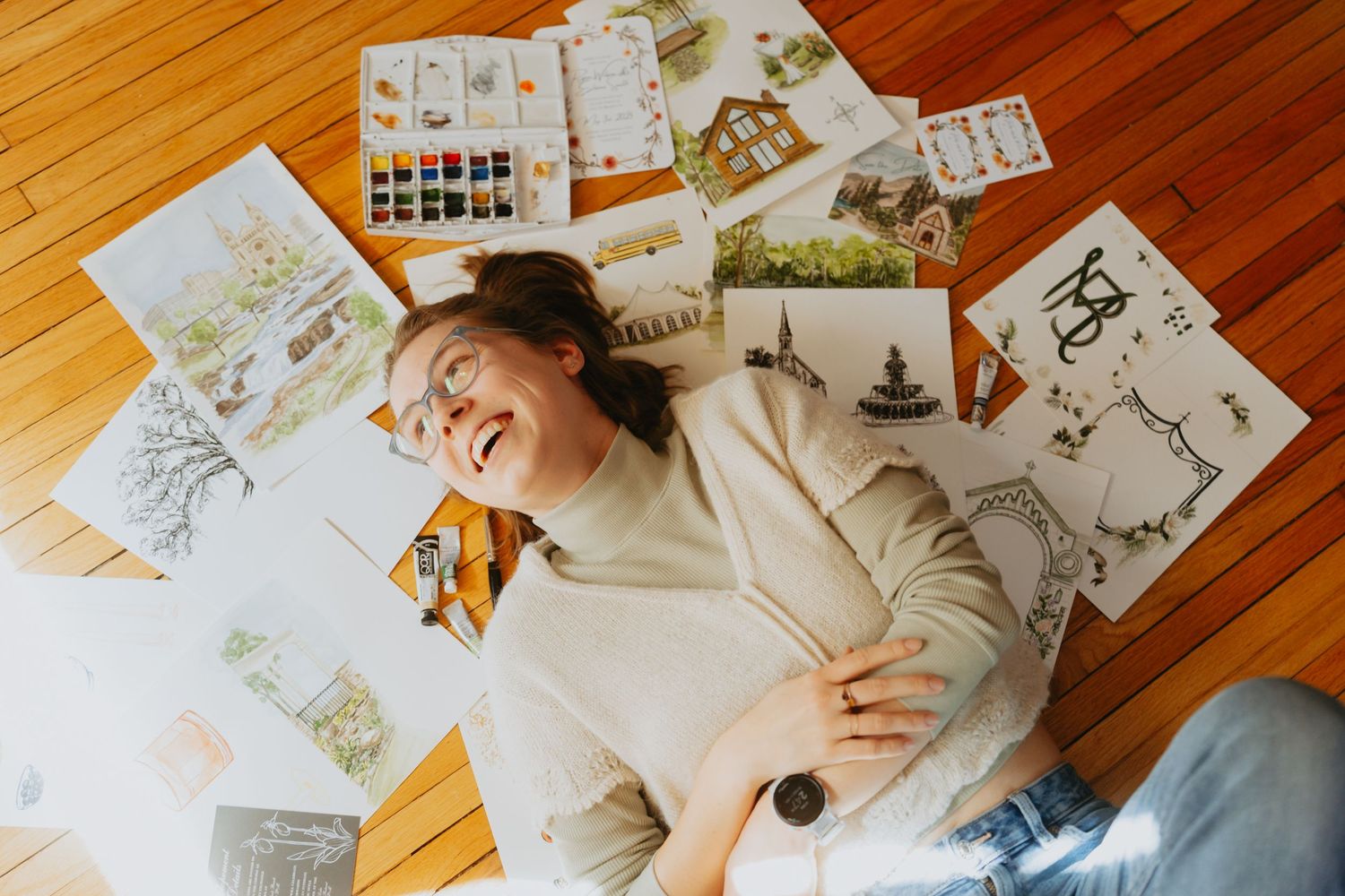 Artist laying amongst her paintings