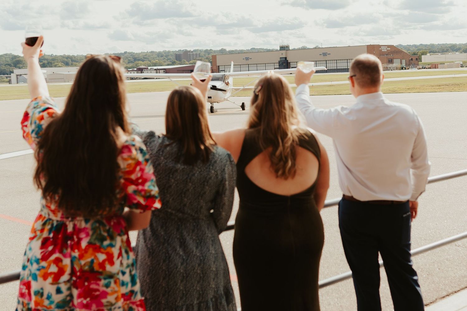 Wedding guests toast to the bride and groom's plane landing.