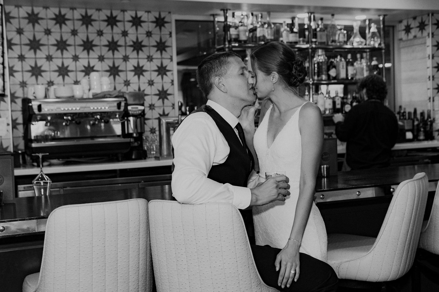 Bride and groom kissing at the bar.