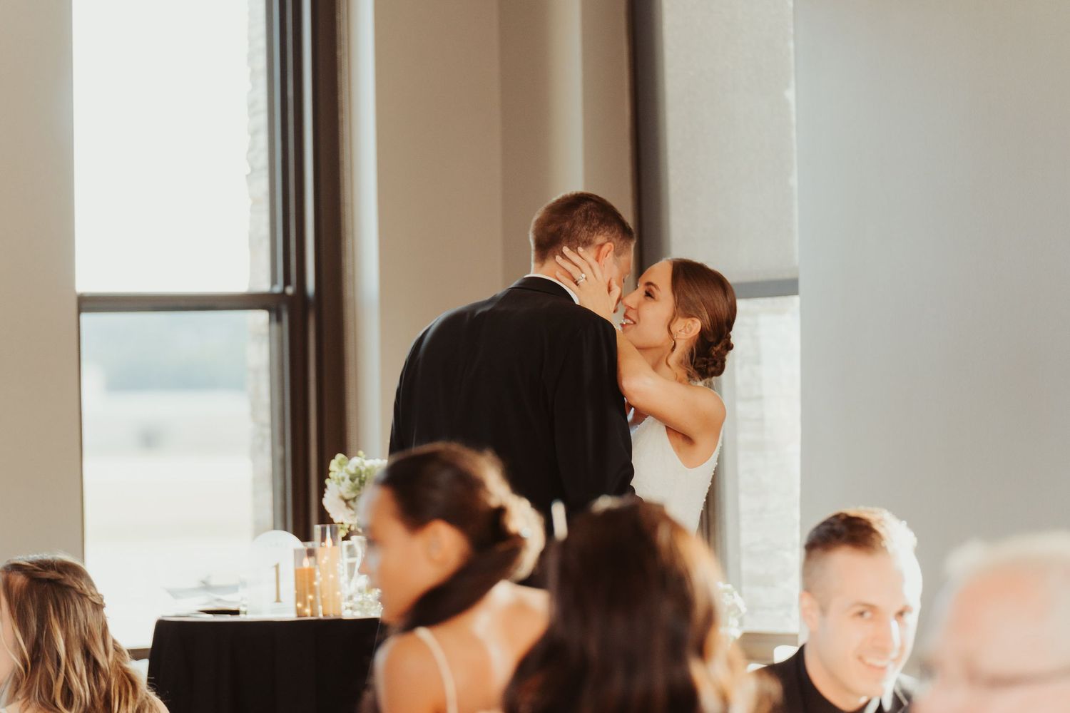 Bride and groom kiss after making toasts.