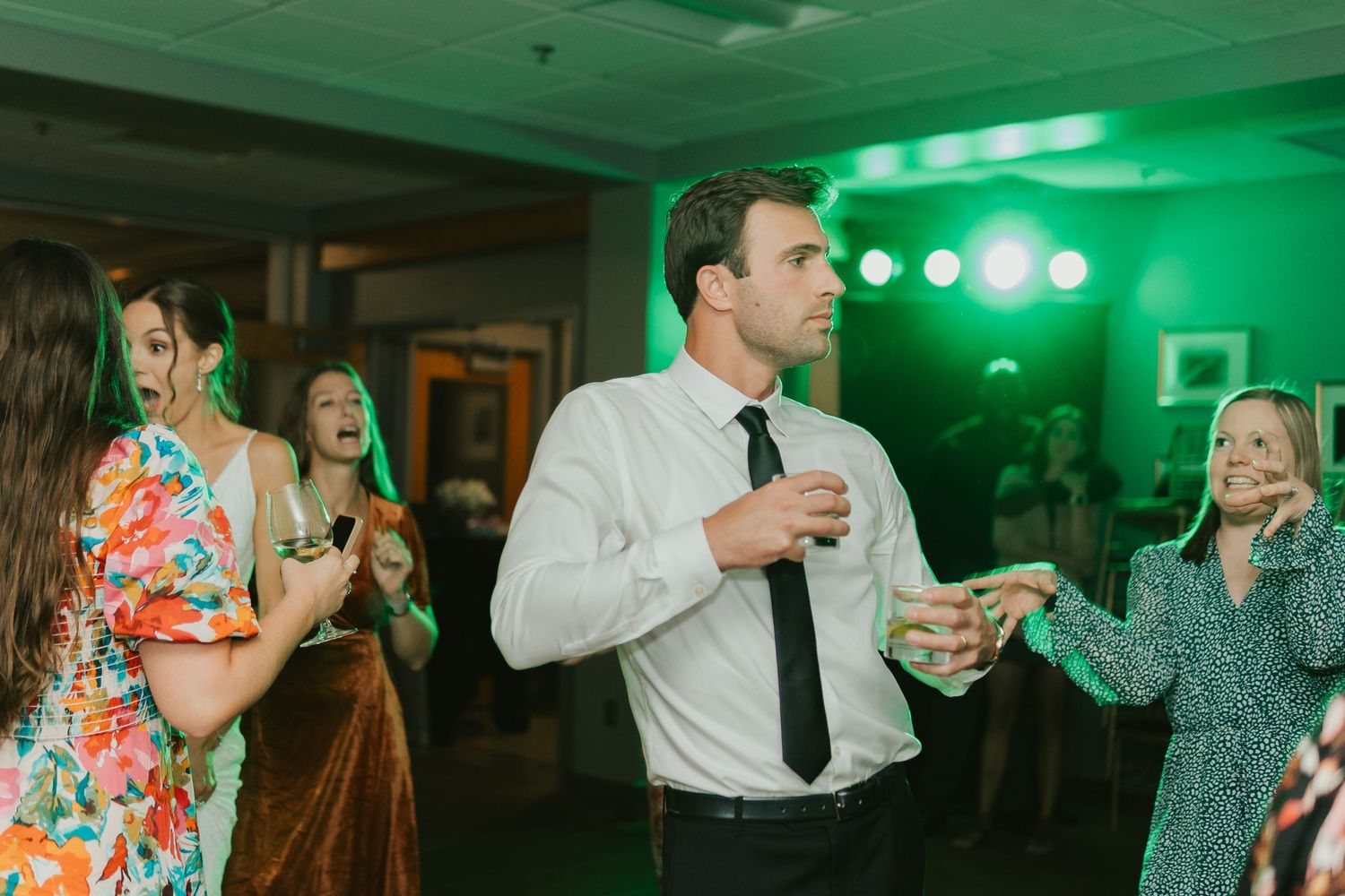 Wedding guest dancing while holding drinks.