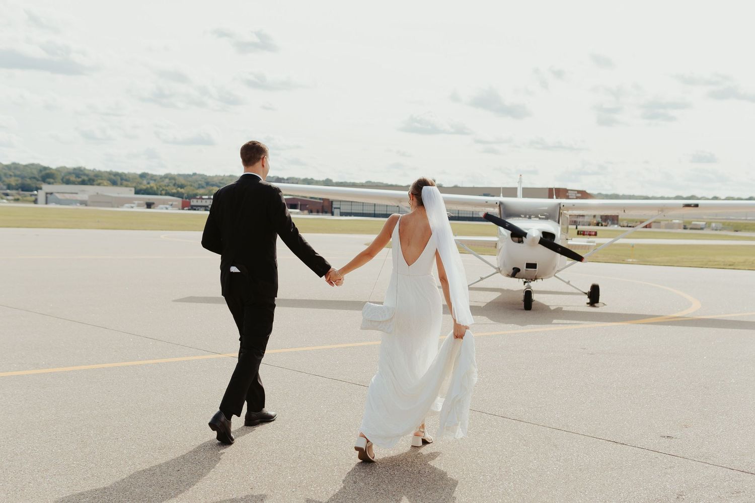 Bride and groom in front of a private plane outside the venue.