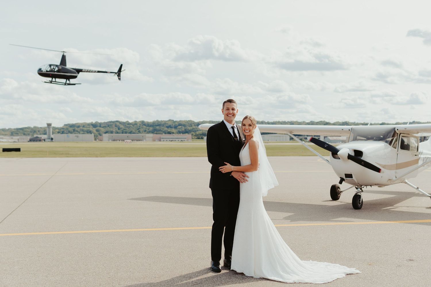 Bride and groom in front of a private plane outside the venue.