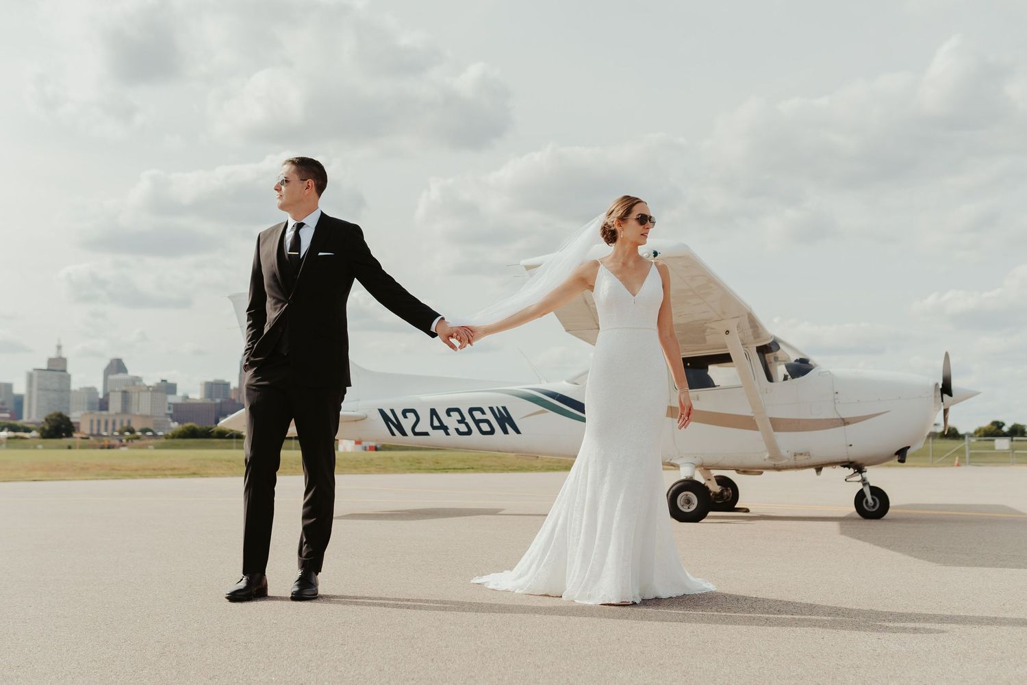 Bride and groom in front of a private plane outside the venue.