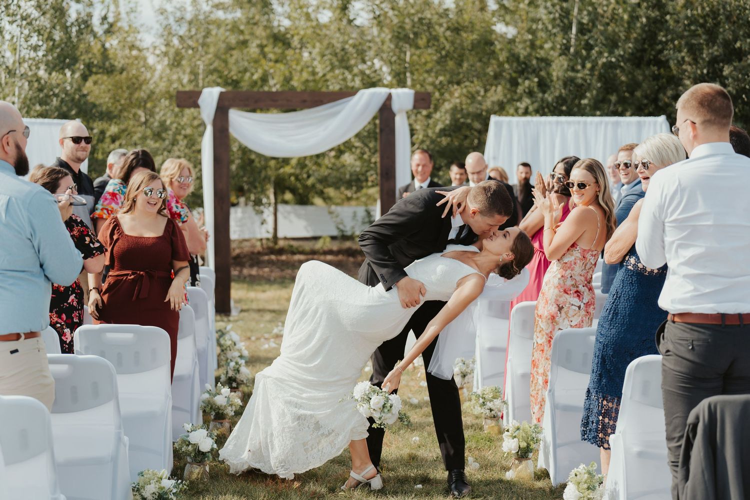 Bride and groom kiss mid-aisle after the ceremony.