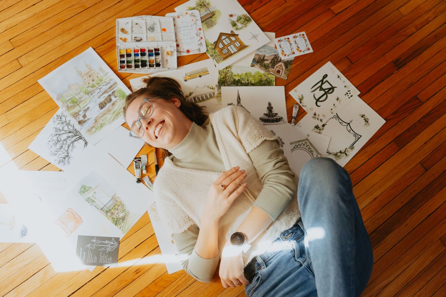 Artist laying amongst her paintings