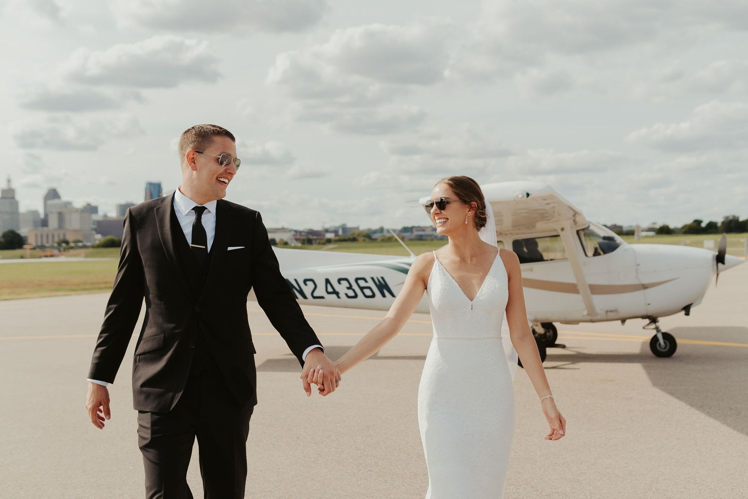 Bride and groom in front of a private plane outside the venue.