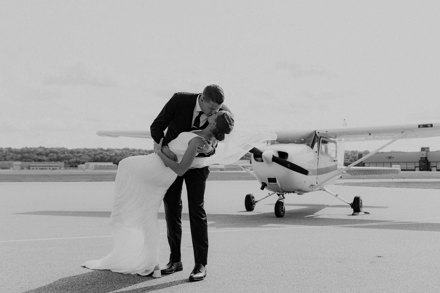 Bride and groom in front of a private plane outside the venue.