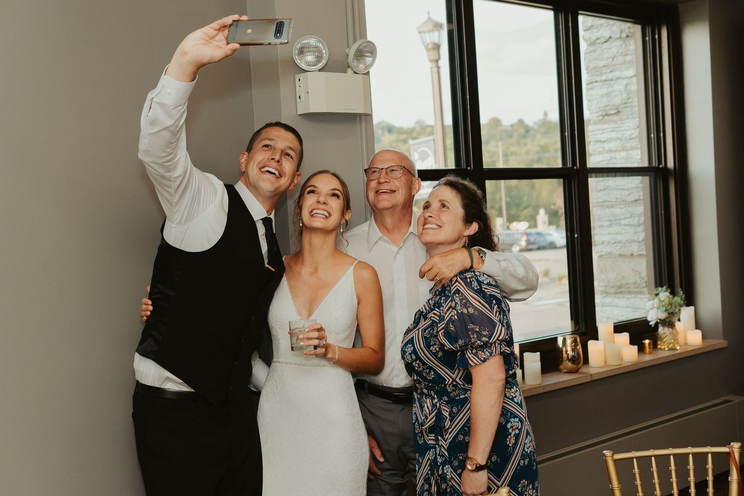 Bride and groom pose for a selfie with wedding guests.