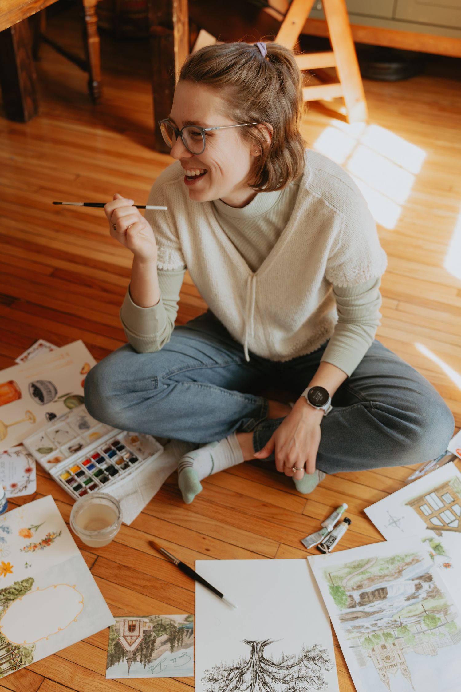 Artist sitting amongst her paintings