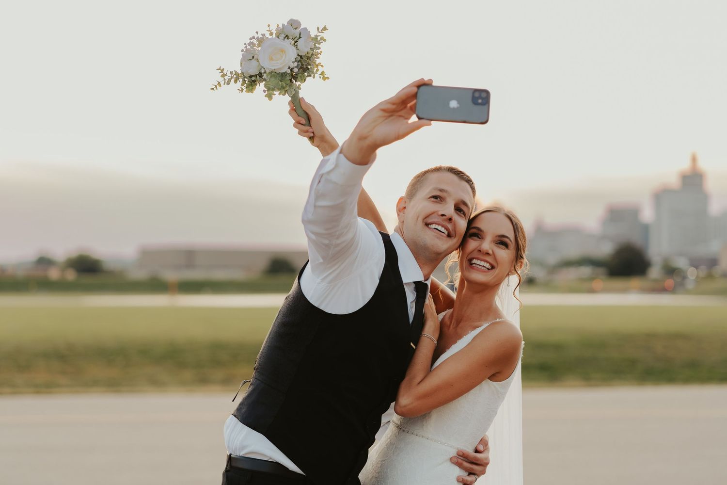 Wedding couple takes a selfie at golden hour.
