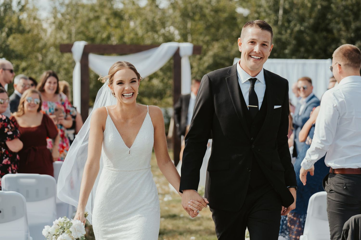 Bride and groom joyfully walking down the aisle after the ceremony.