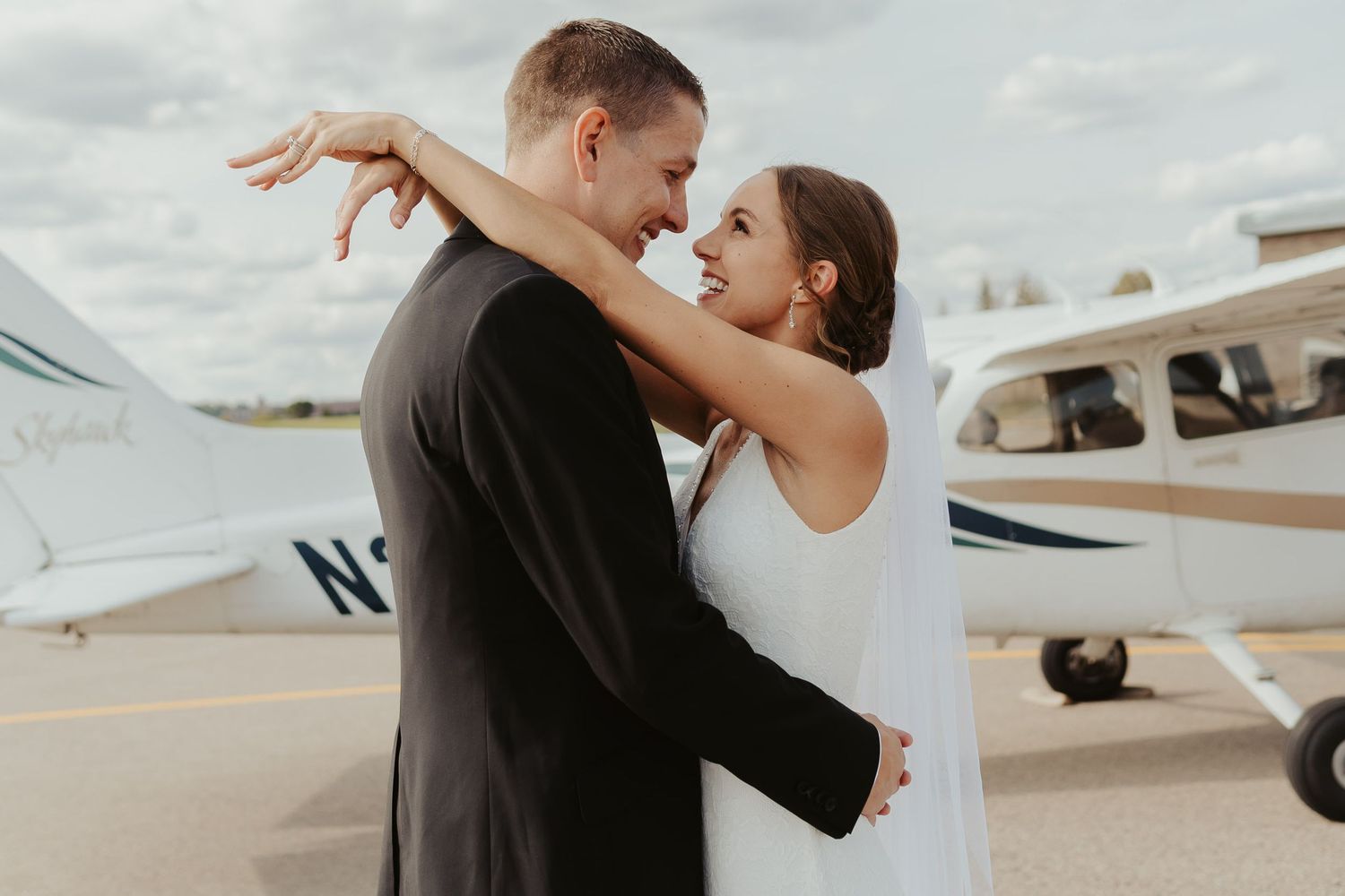 Bride and groom in front of a private plane outside the venue.