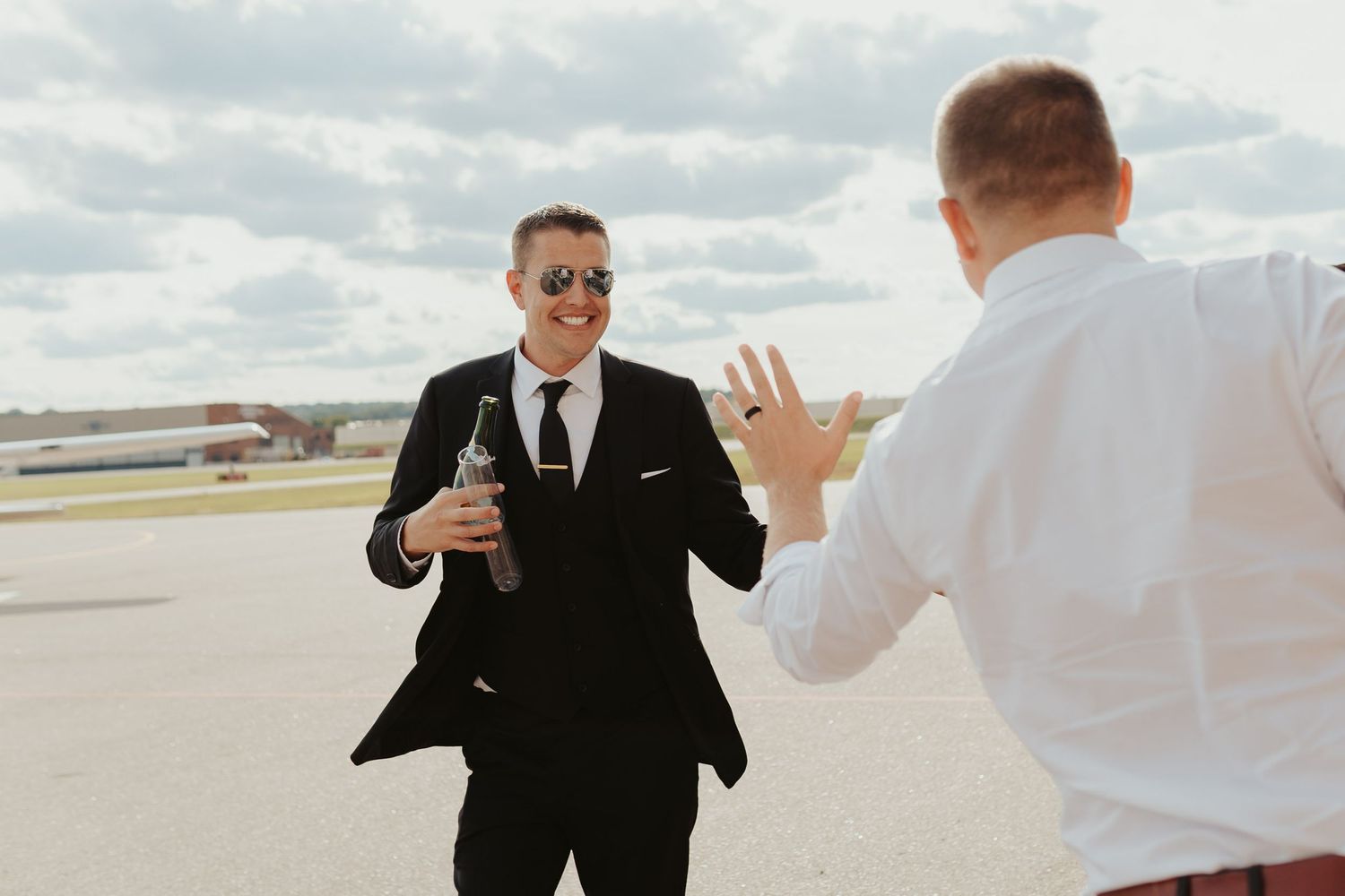 Groom high fives wedding guest.