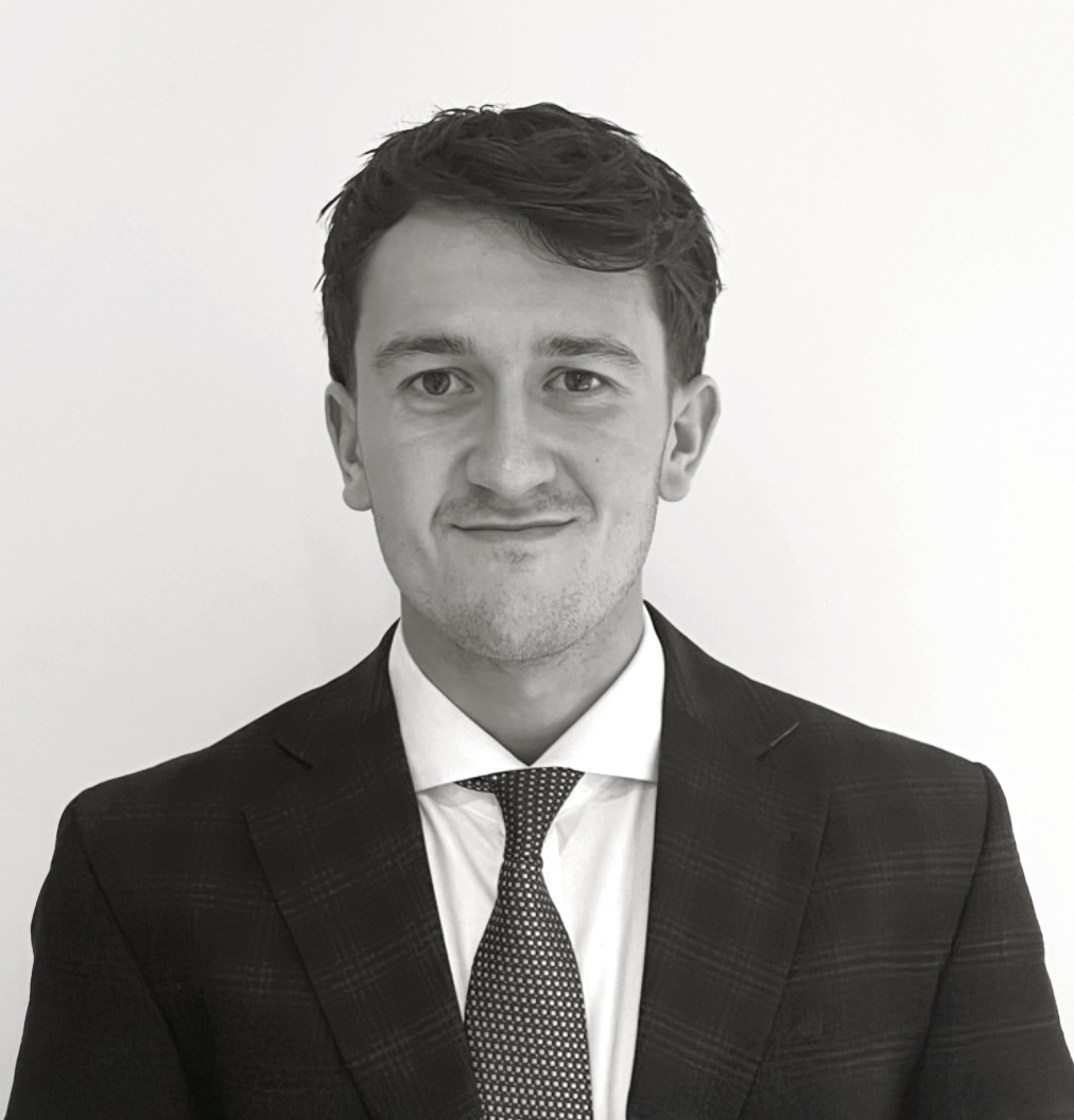 Professional black and white headshot of a young businessman wearing a suit and tie.