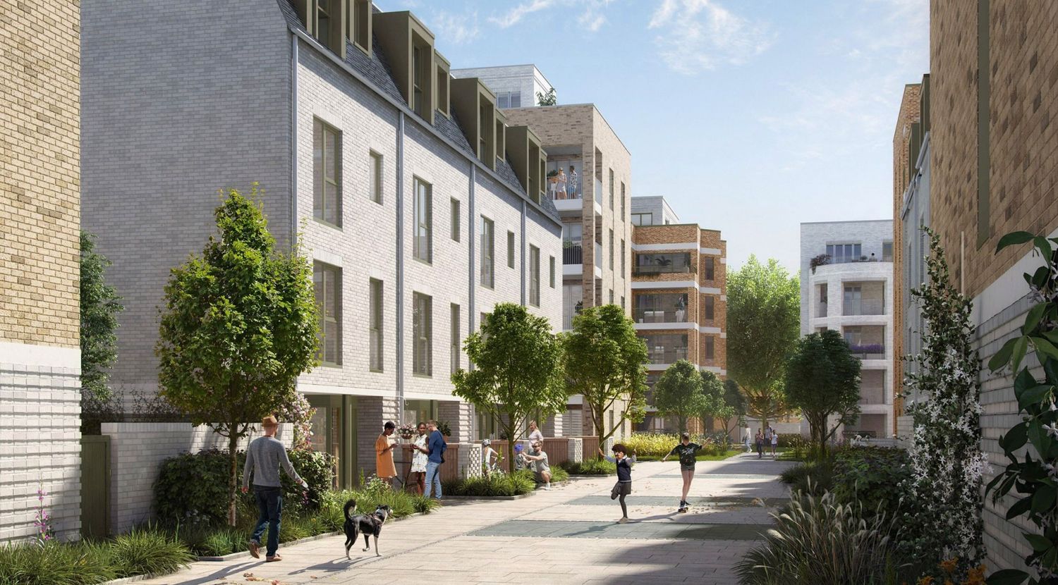 Modern residential street with brick townhouses, lush trees, and pedestrians walking a dog on a sunny day.