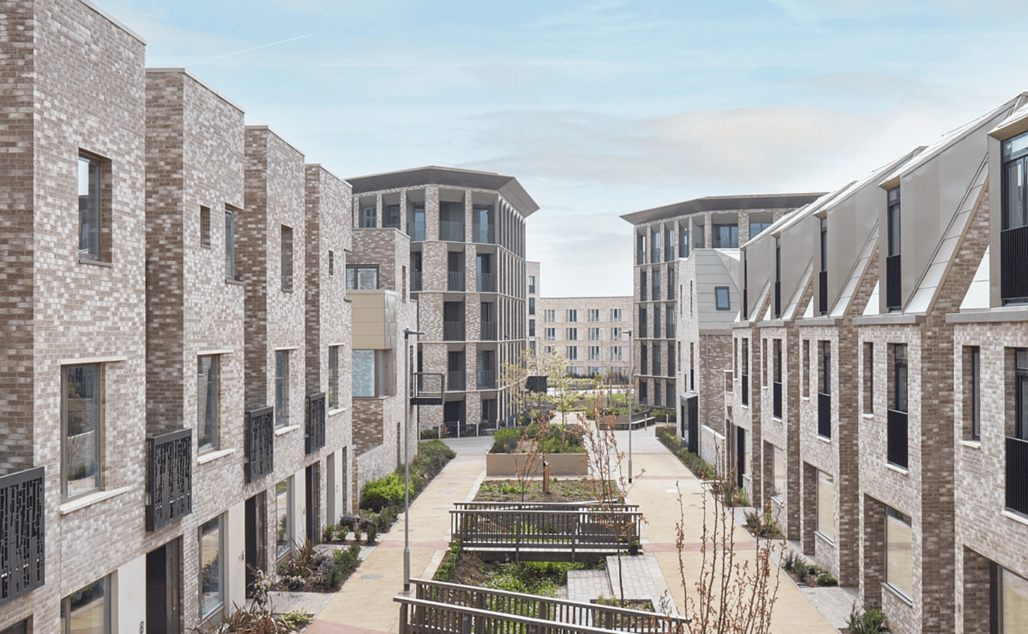 Modern brick apartment complex with landscaped courtyard garden in contemporary urban residential development.