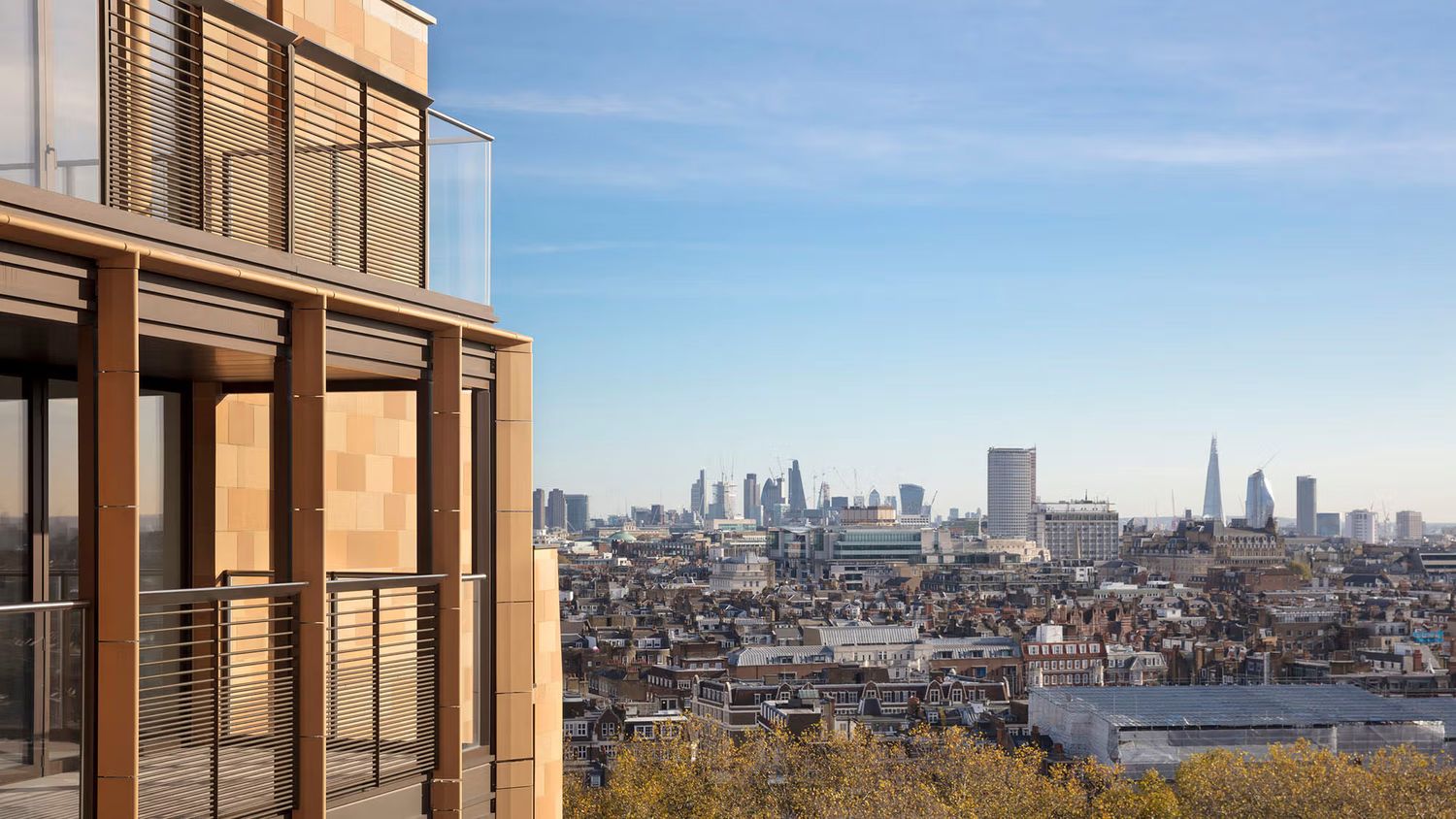 Modern luxury building balcony overlooking panoramic London skyline with The Shard visible on a clear sunny day.