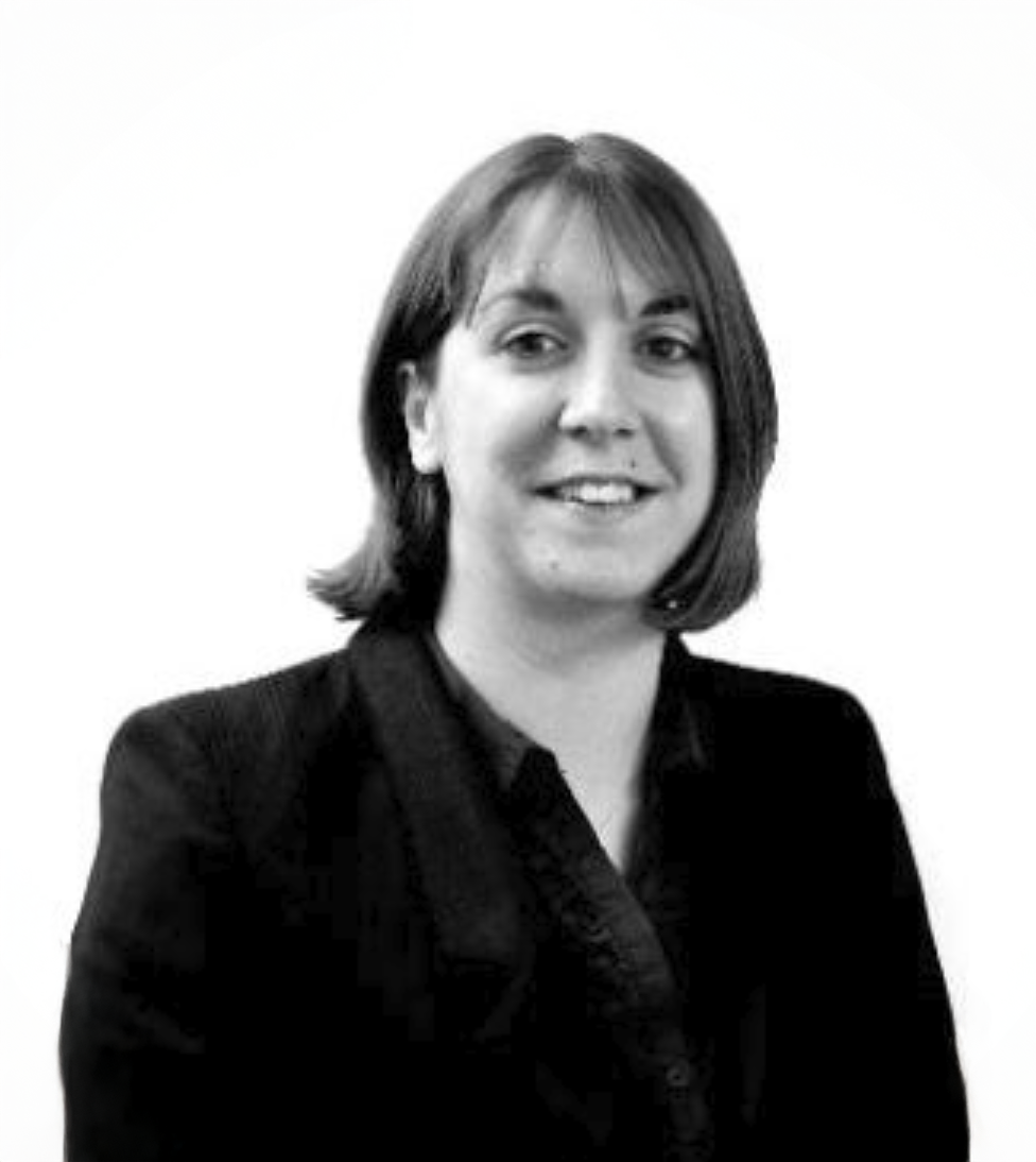 Professional black and white headshot of a smiling woman with short dark hair wearing a dark blazer.