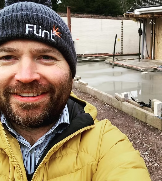 Someone wearing a yellow jacket and knit hat smiles in three similar outdoor selfie photos.
