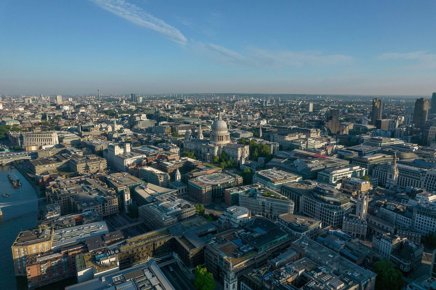 Aerial panoramic view of London skyline featuring St. Paul's Cathedral dome and River Thames on a clear day.