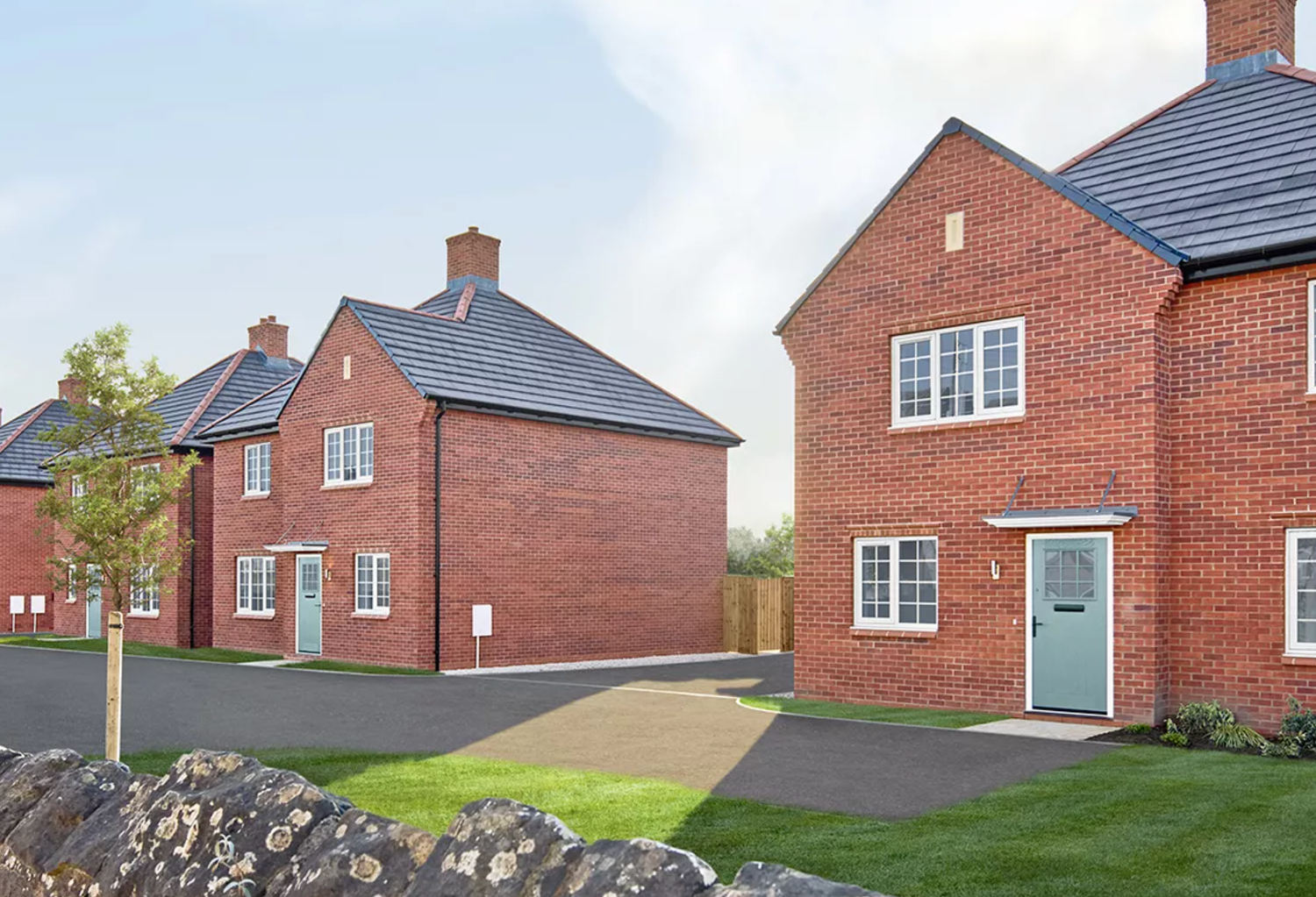 Panoramic view of modern red brick houses in a new residential development with well-maintained lawns and pathways.