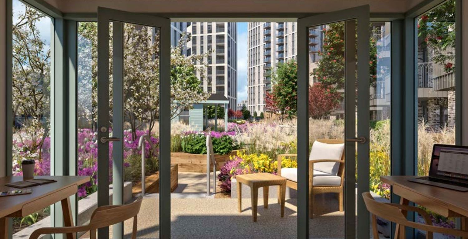 Bright sunroom with open glass doors overlooking a lush garden courtyard with colorful flowers and modern city buildings.