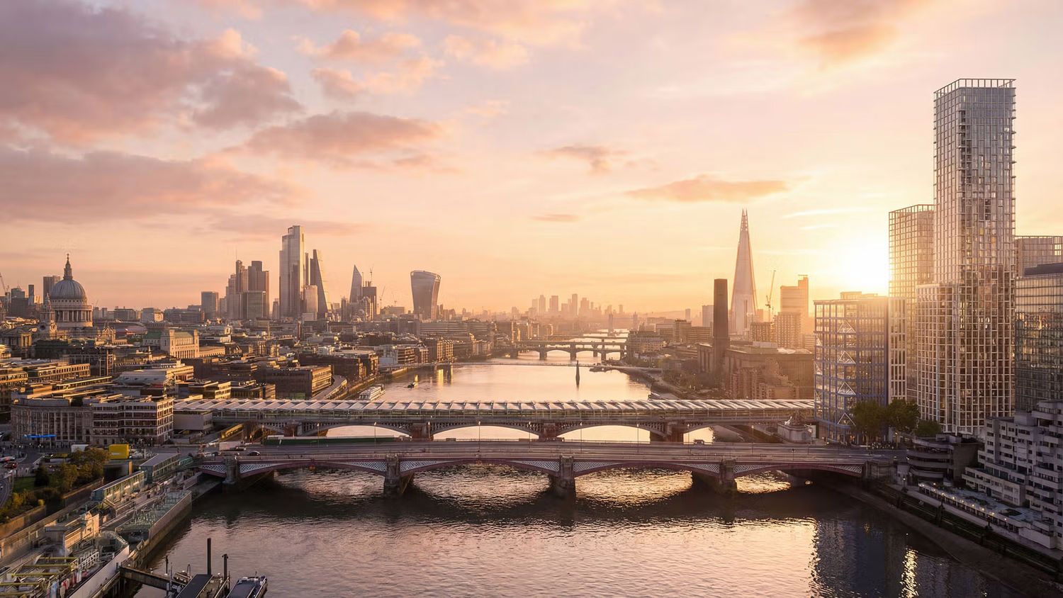 Aerial view of London skyline at sunset with the Thames River, bridges, The Shard, and golden sky.