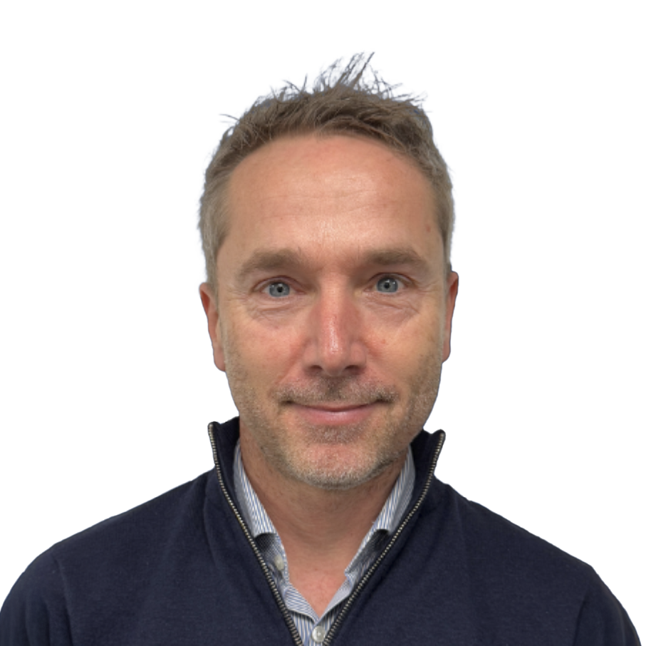 Professional headshot of a middle-aged man with short blonde hair wearing a navy zip-up sweater over a collared shirt.