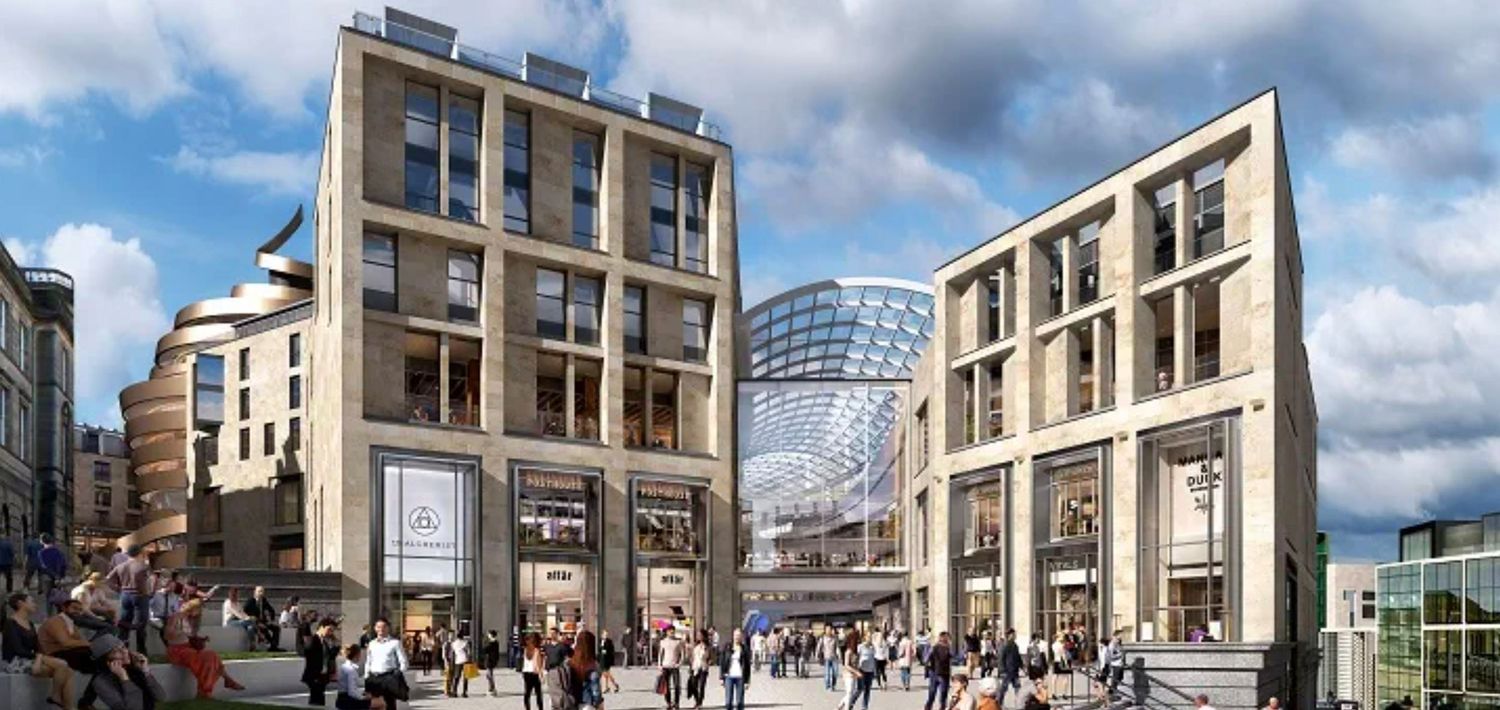 Modern urban shopping complex with pedestrians, glass dome, and contemporary stone buildings under a blue sky.