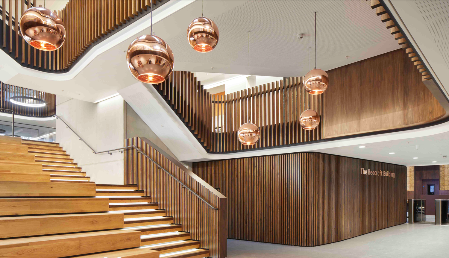 Modern interior staircase with wooden paneling and pendant lighting creating an elegant atmosphere.