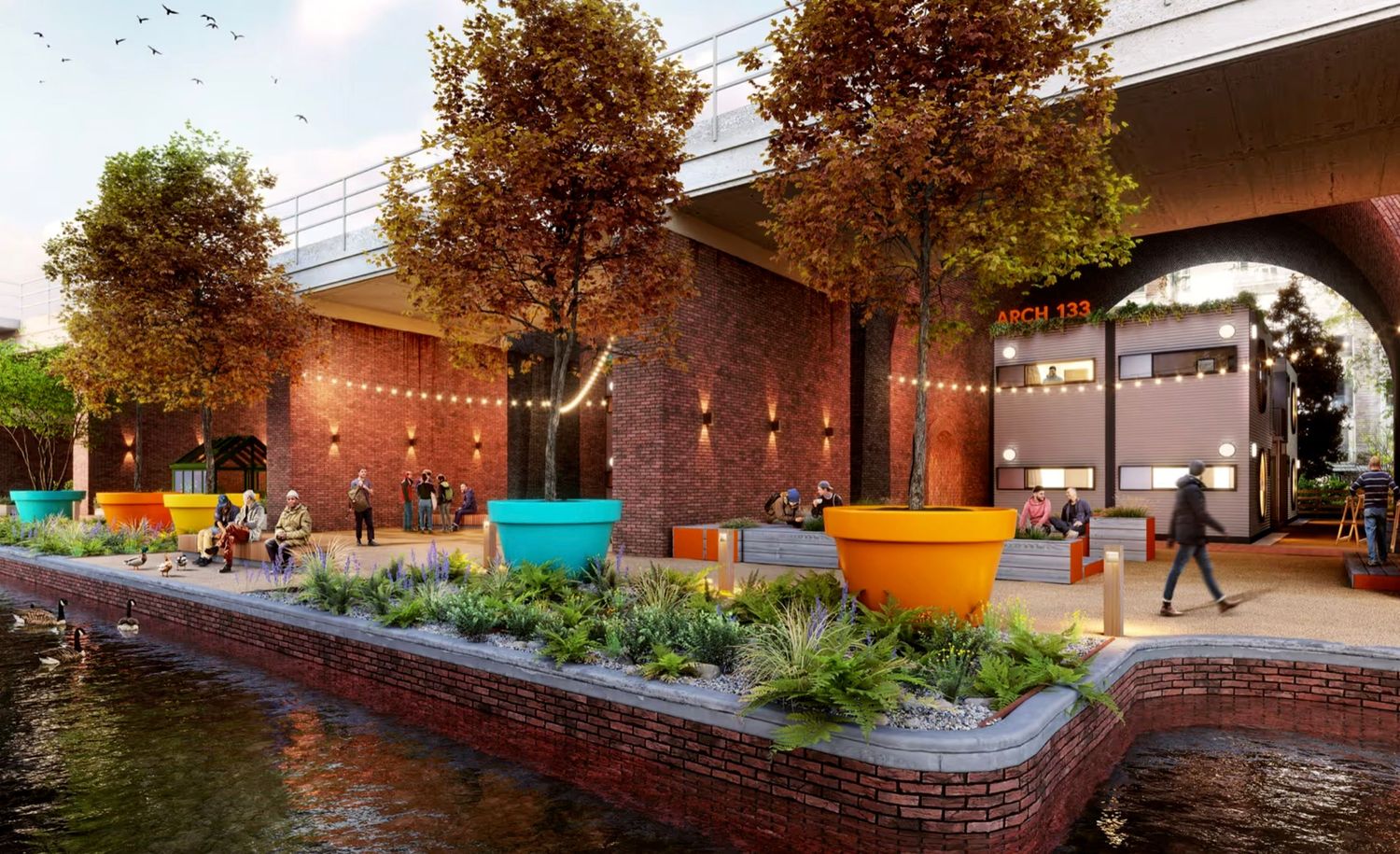 Vibrant urban waterfront plaza with colorful planters, string lights, brick arches, and lush greenery at dusk.