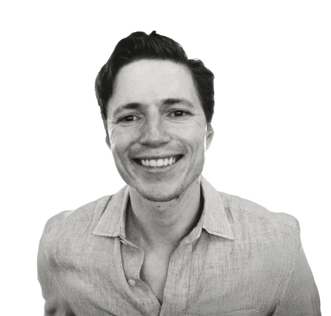 Smiling young man with dark hair wearing a light linen shirt, black and white professional headshot photo.