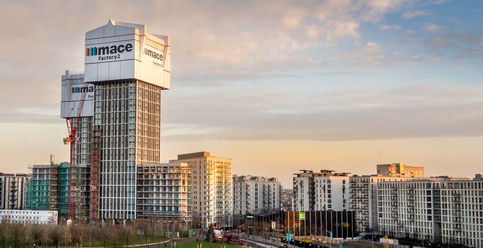 Mace Group headquarters tower building at sunset in urban London cityscape with modern residential buildings.