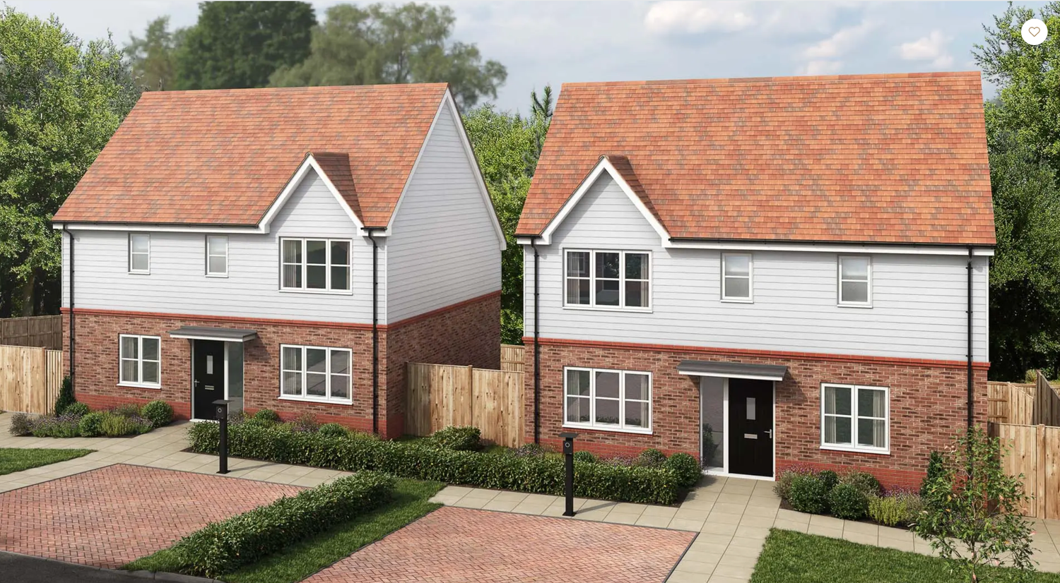 Two modern white detached houses with terracotta colored roofs and brick details stand side by side in a residential development.