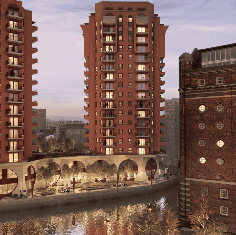 Modern red brick residential towers reflecting in a canal at dusk, with arched waterfront promenade in urban setting.